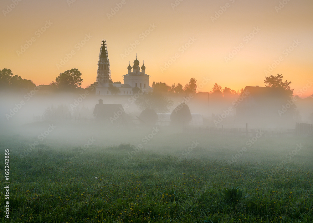 Obraz premium Misty morning overlooking the Kazan Church and the Church of St. John the Warrior in the village of Osenevo, Gavrilov-yamskiy district of the Yaroslavl region. Russia