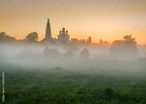 Misty morning overlooking the Kazan Church and the Church of St. John the Warrior in the village of Osenevo, Gavrilov-yamskiy district of the Yaroslavl region. Russia