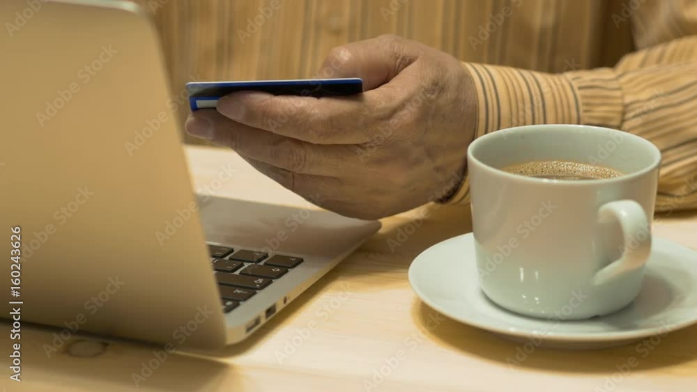 An Elderly Man Shopping Online At Laptop With Credit Card An Elderly Man Shopping Online At Laptop With Credit Card