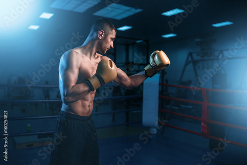 Portrait of muscular boxer in black gloves