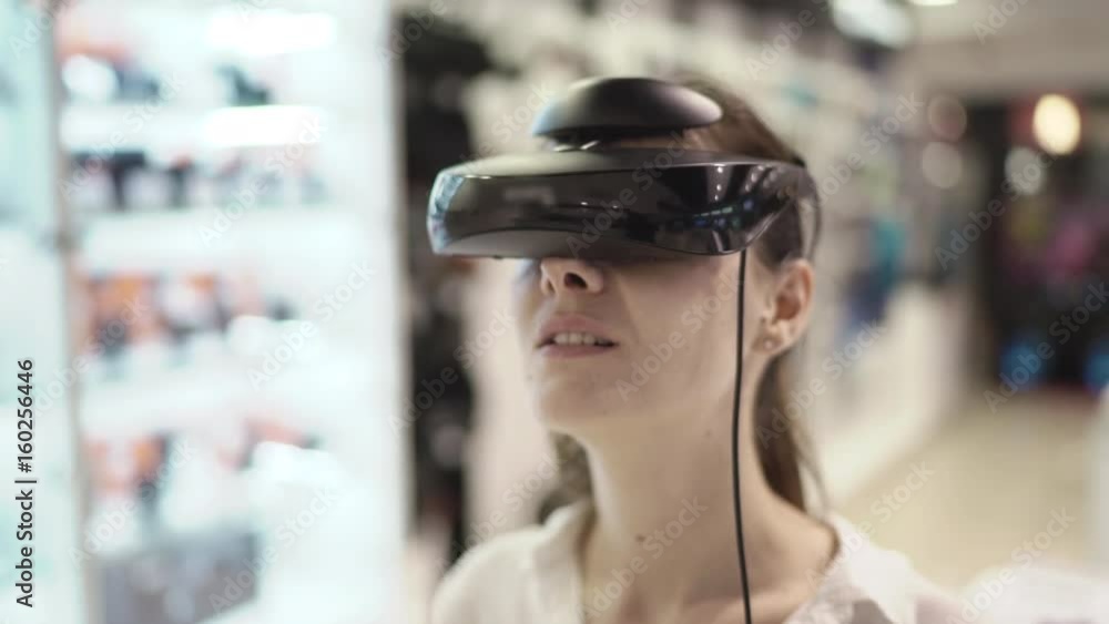 Young woman getting experience in using vr-headset in a mall. Close up Young woman getting experience in using vr-headset in a mall. Close up