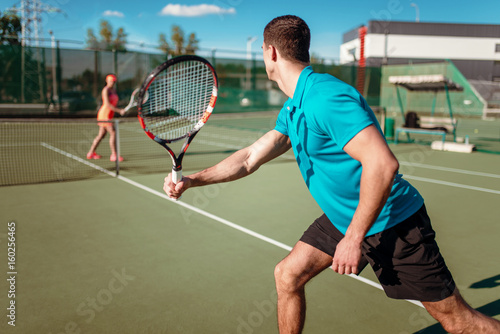 Athletic man and slim woman on tennis training