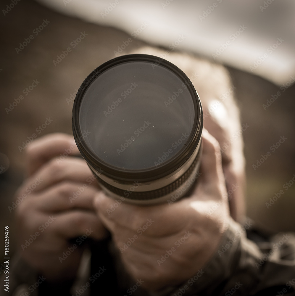 Photographer takes a photo with a large lens Photographer takes a photo with a large lens