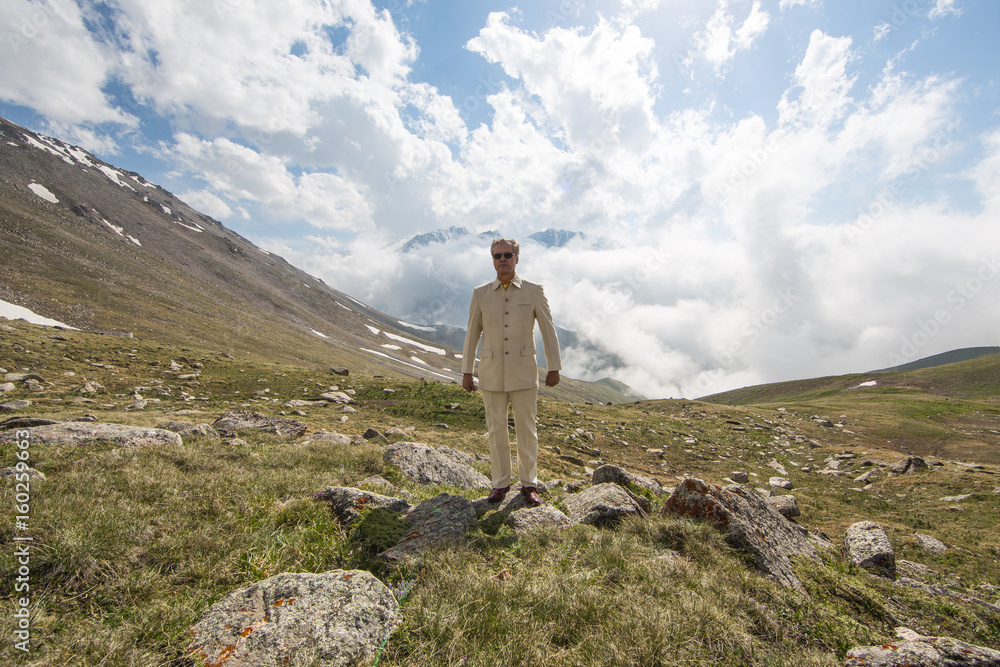 A man in a white suit on a mountain