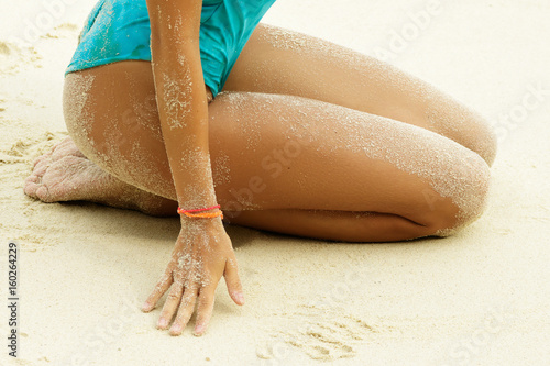 Obraz na płótnie Female hips covered with a sand