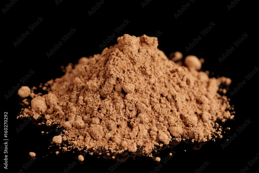 Organic cocoa powder isolated on black background Organic cocoa powder isolated on black background