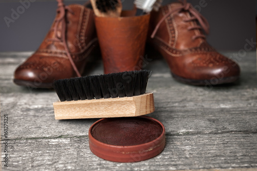Cleaning brush, polish cream and brown shoes