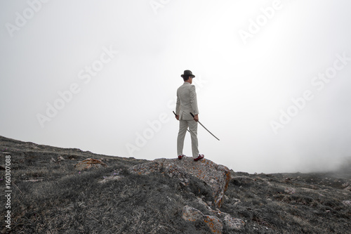 Businessman with swords in nature  man in mountains