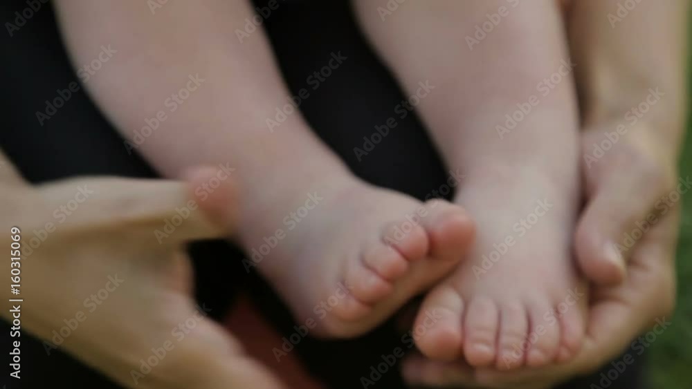Mom holds baby's feet in hands
