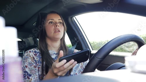 Woman texting message with cell phone while driving car getting distracted danger