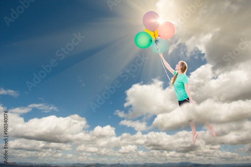 Young Adult Female Being Carried Up and Away Into The Clouds By Balloons That She Is Holding.