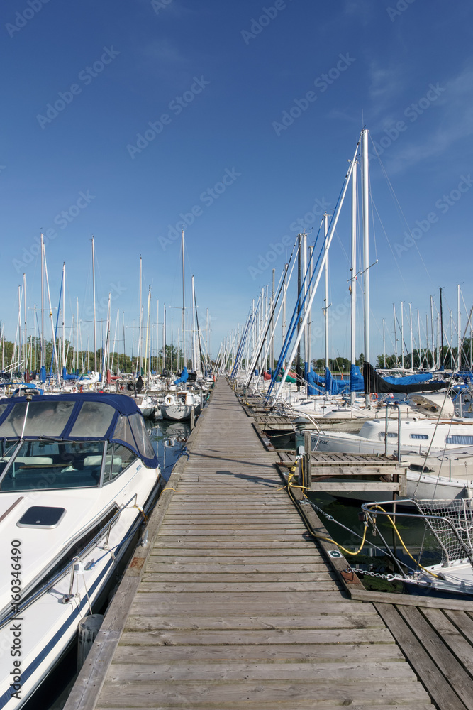 Fototapeta premium Stationary sailing boats alongside a pier, Toronto, Ontario, Canada, summer.