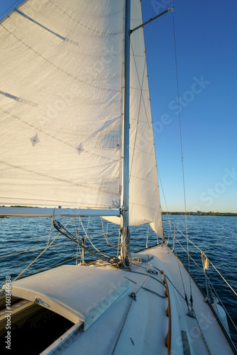 Sail on boat out at sea, with horizon, sunny day.