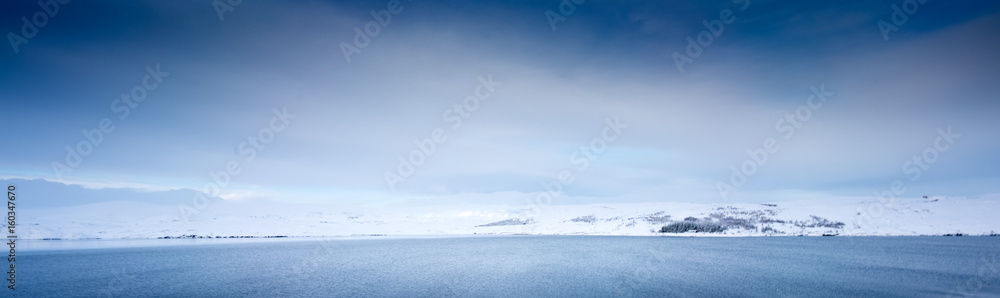 Snow covered landscape, blue sky and distant mountain, Iceland, Europe.