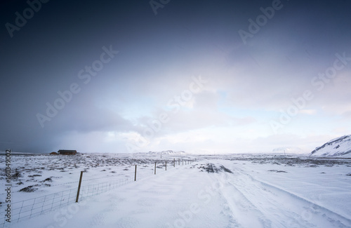 Cosy log cabin in snow covered landscape, distant, Iceland, Europe.