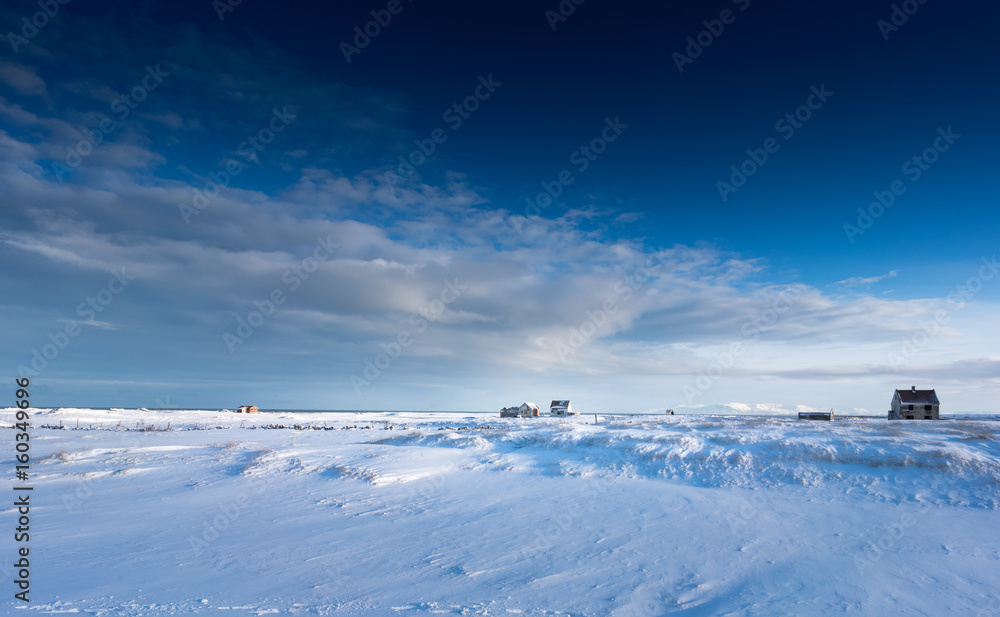 Buildings situated on deep snow covered landscape, distant, Iceland, Europe.