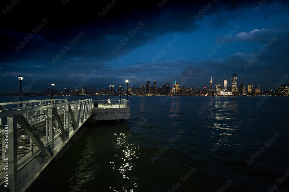 View of New York City from marina at night, New York, USA.