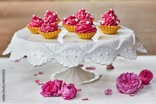 Pink cupcakes decorated with pearls, hearts and roses