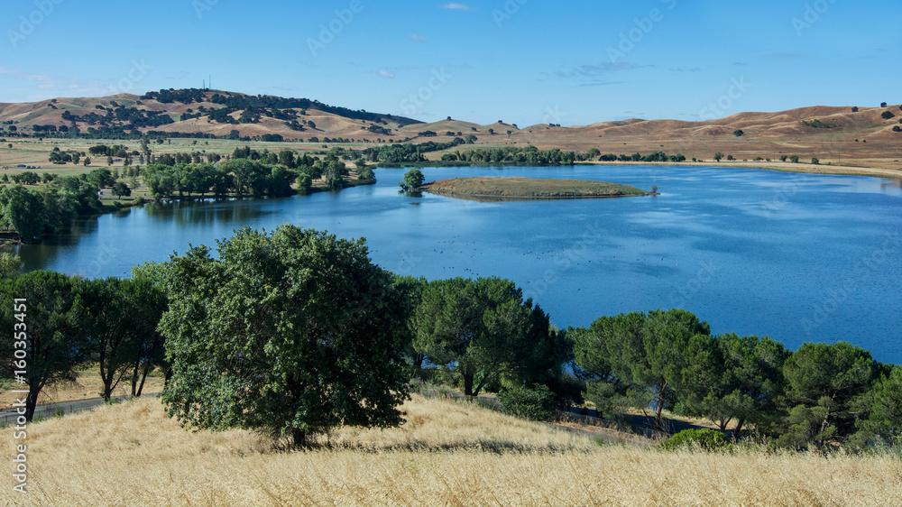 Panoramic view of the Lagoon Valley Park in Vacaville, California, USA, featuring the chaparral in the spring, with golden grass, and the lake