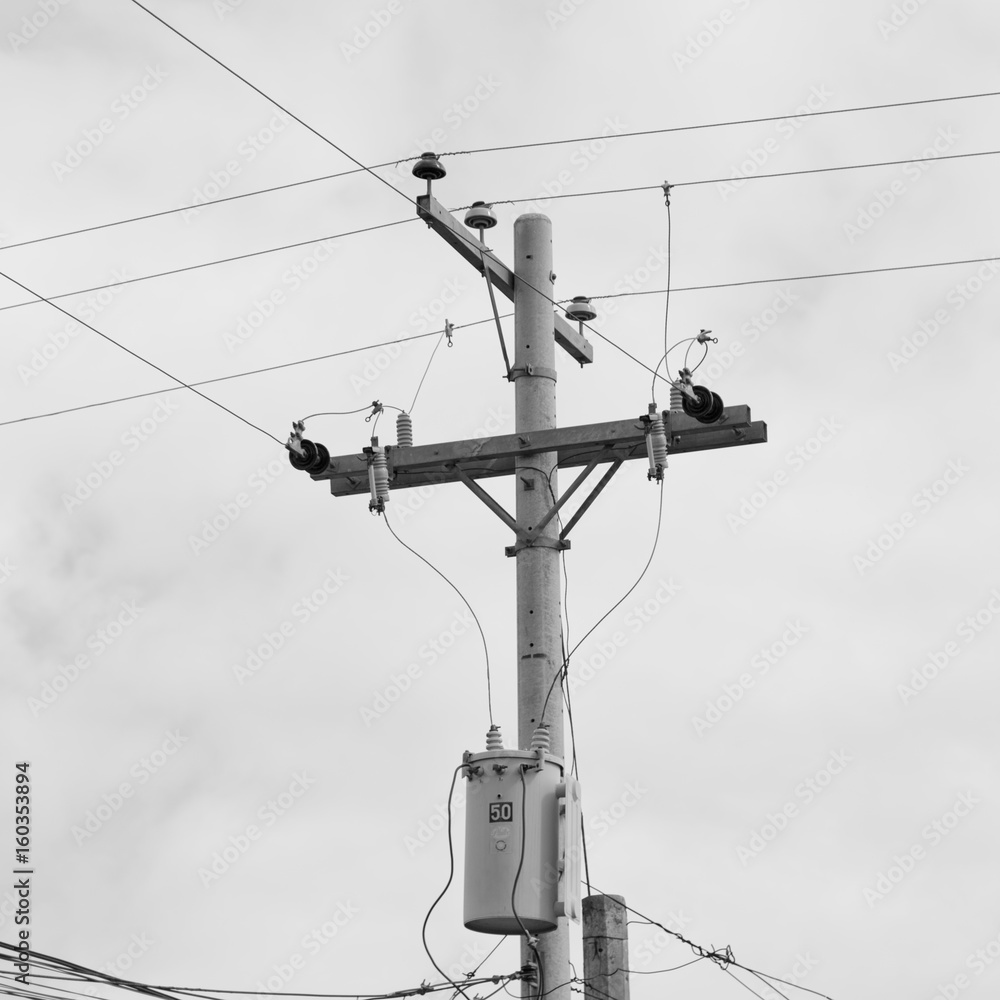 a electric pole with transformer and wire  the cloudy sky