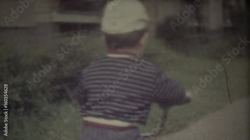 Family Chronicle: Happy toddler riding his bike. Father shooting family video