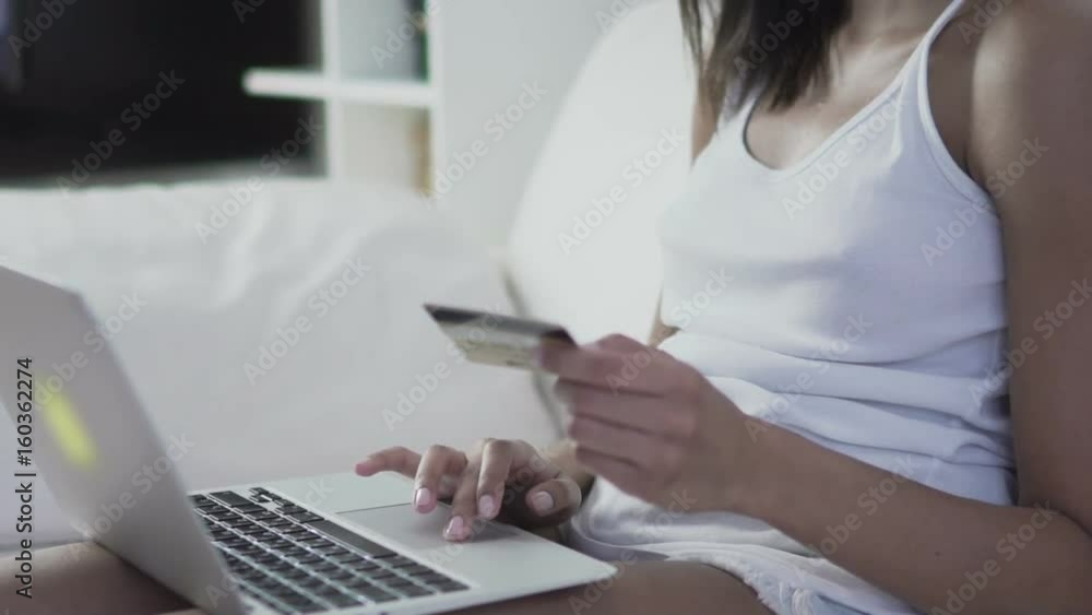 Woman holding credit card in hand purchasing online shopping with her laptop. 60 fps (for slow motion) Woman holding credit card in hand purchasing online shopping with her laptop. 60 fps (for slow motion)