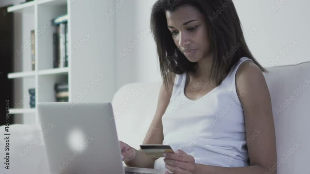 Woman holding credit card in hand purchasing online shopping with her laptop. Slow motion 120fps Woman holding credit card in hand purchasing online shopping with her laptop. Slow motion 120fps