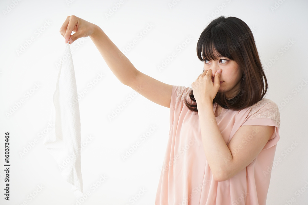 Naklejka premium Young woman smelling stinky laundries