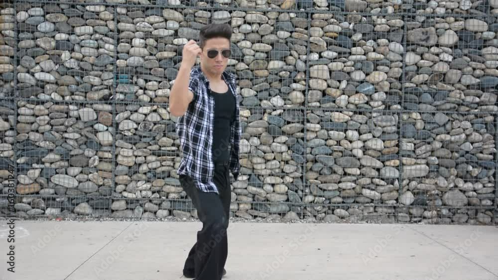 Young male trendy hip-hop dancer outside, doing break-dance in city setting Young male trendy hip-hop dancer outside, doing break-dance in city setting