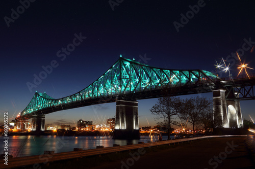 Jacques Cartier Bridge Illumination in Montreal, reflection in water. Montreal’s 375th anniversary. luminous colorful interactive Jacques Cartier Bridge. Bridge panoramic colorful silhouette by night. photo