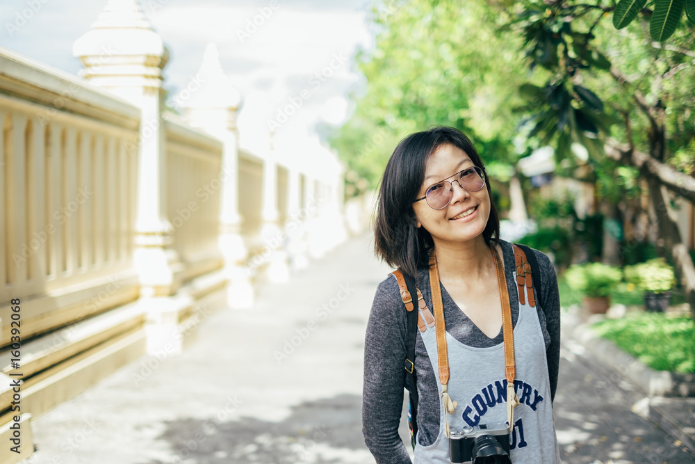 Woman tourist with camera smile in the thai temple Woman tourist with camera smile in the thai temple