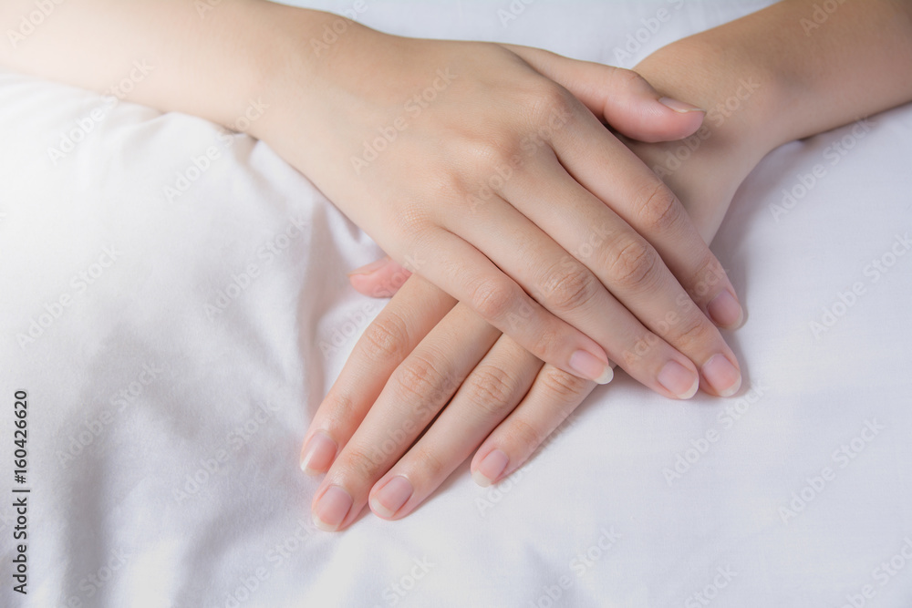 Hands of woman cover the hand her self. ladies hands on white fabric. Hands of woman cover the hand her self. ladies hands on white fabric.