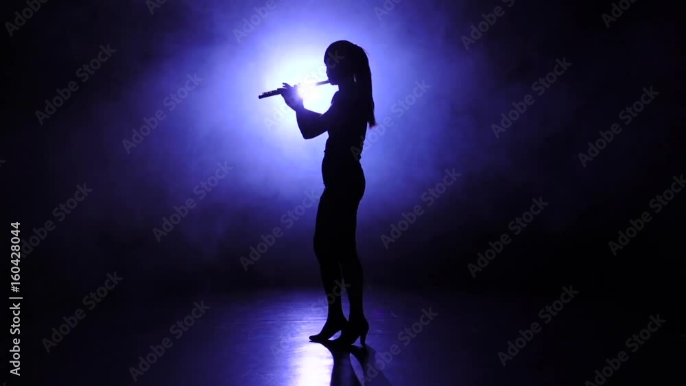 Melody performed girl playing on flute in slow motion. Smoky Melody performed girl playing on flute in slow motion. Smoky