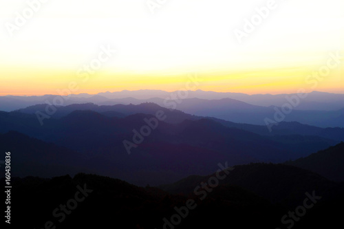 Beautiful Mountain And Sunset at doi come fah, chiang mai Thailand. Dark Silhouette of Mountains with Yellow Sunrise Background.