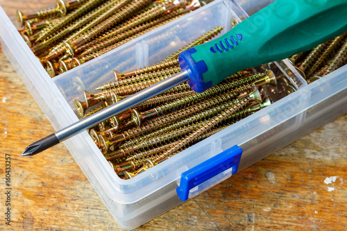 Long self-tapping screws in the storage box and screwdriver on the workbench