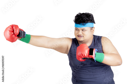 Overweight man doing boxing exercise © Creativa Images