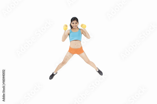 Pretty woman jump with dumbbells