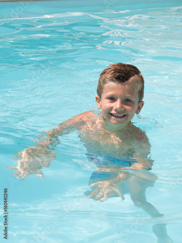 happy kid boy swimming in pool resort
