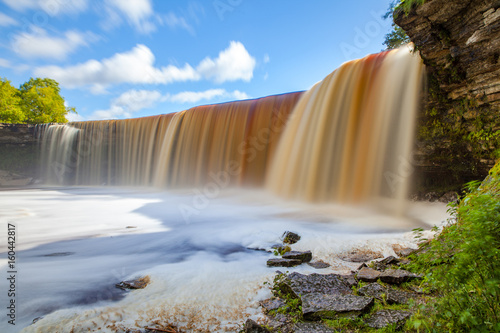 Jagala is the biggest waterfall in Estonia. Long exposure day shot. Close up. Water is red due to swamp organics.