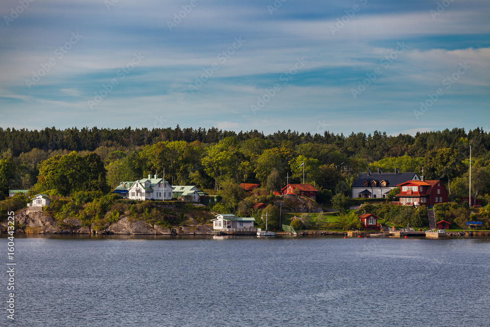 View on small cabins on an island in Stockholm archipelago, Sweden. Summer sunrise time.