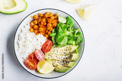 Slika na platnu Healthy lunch bowl: basmati rice, chickpeas in tomato sauce, avocado, cherry tomatoes, corn salad