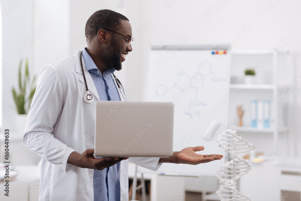 Happy smart doctor pointing at the DNA model Happy smart doctor pointing at the DNA model