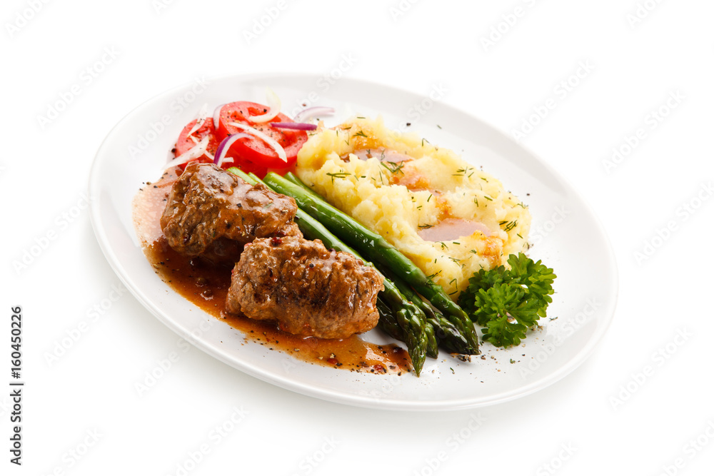 Wrapped pork chops with potatoes and asparagus on white background Wrapped pork chops with potatoes and asparagus on white background