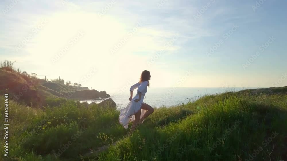 Happy beautiful romantic healthy curly girl run hill coast sunrise drone footage Happy beautiful romantic healthy curly girl run hill coast sunrise drone footage
