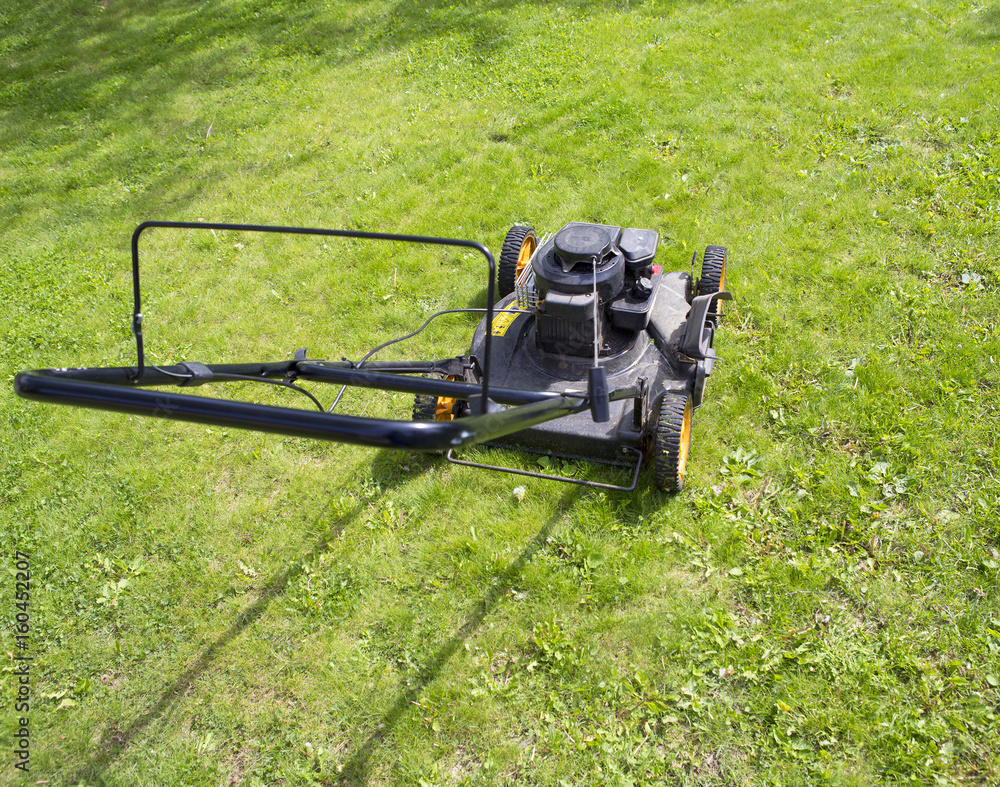 Fresh green grass mowed. An image of a black mower. Fresh green grass mowed. An image of a black mower.