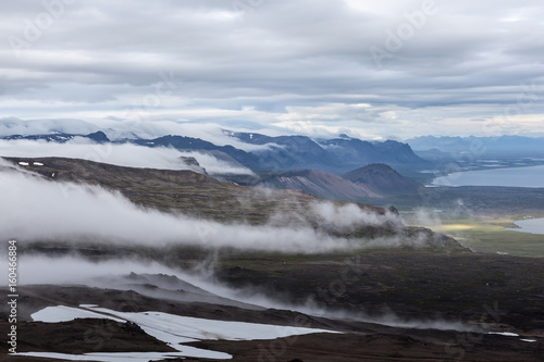 Clouds flowing low in the Iceland mountain landscape - view from the slope of Snaefellsjokull volcano. Hiking in Saefellsnes peninsula in western Iceland. photo