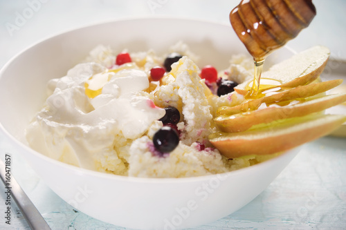 Cottge cheese with sour cream, fruits and honey photo