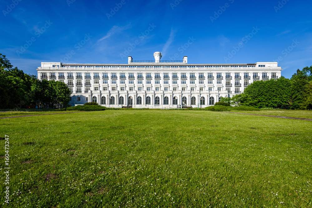 green park with walkways and large white hotel