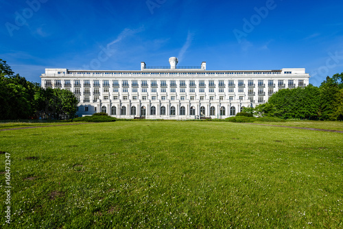 green park with walkways and large white hotel