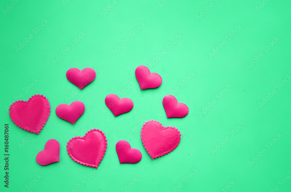 Obraz premium Pink hearts on a green background